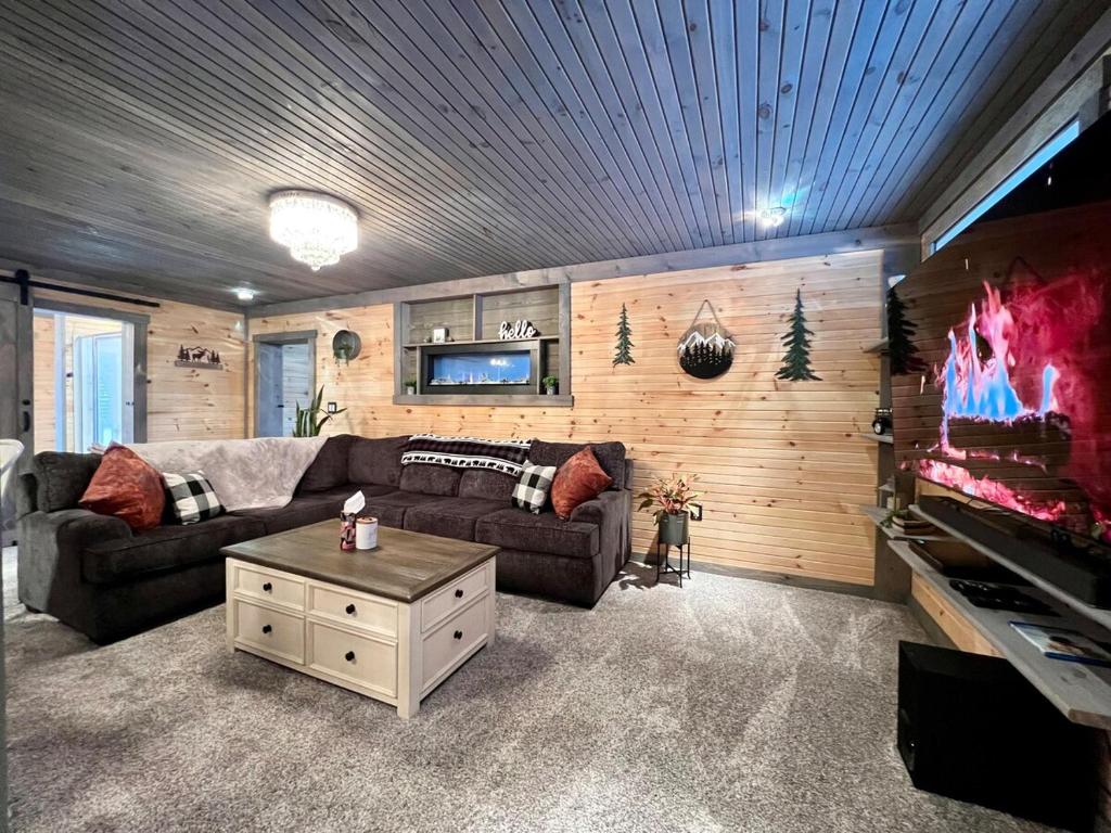 a living room with two couches and a flat screen tv at Copper Kettle Lodge in Cook Forest in Sigel