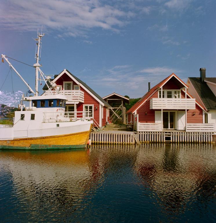 a boat is docked next to houses on the water at Kyn Sjøstuer in Stavang