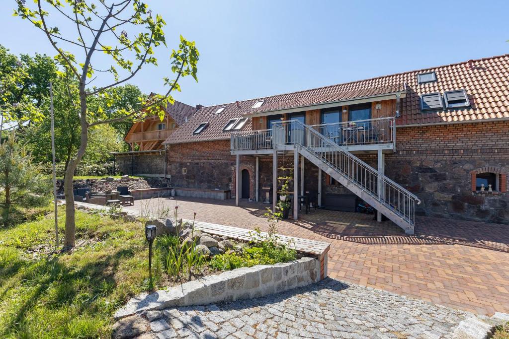 a brick building with a staircase in front of it at Ferienhof am See in Alt Zeschdorf