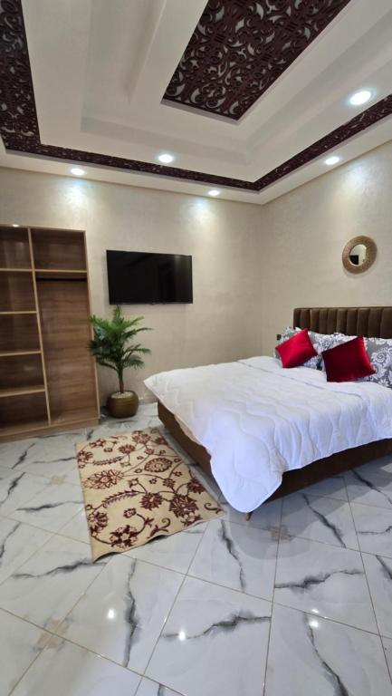 マラケシュにあるNear Airport hostingの大きなベッドと薄型テレビのある寝室