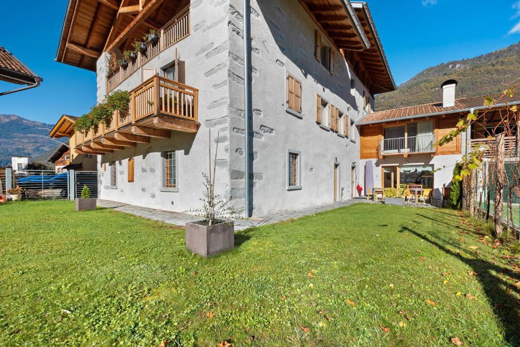 Un gran edificio con balcón y patio. en Appartamento Saone, en Ragoli