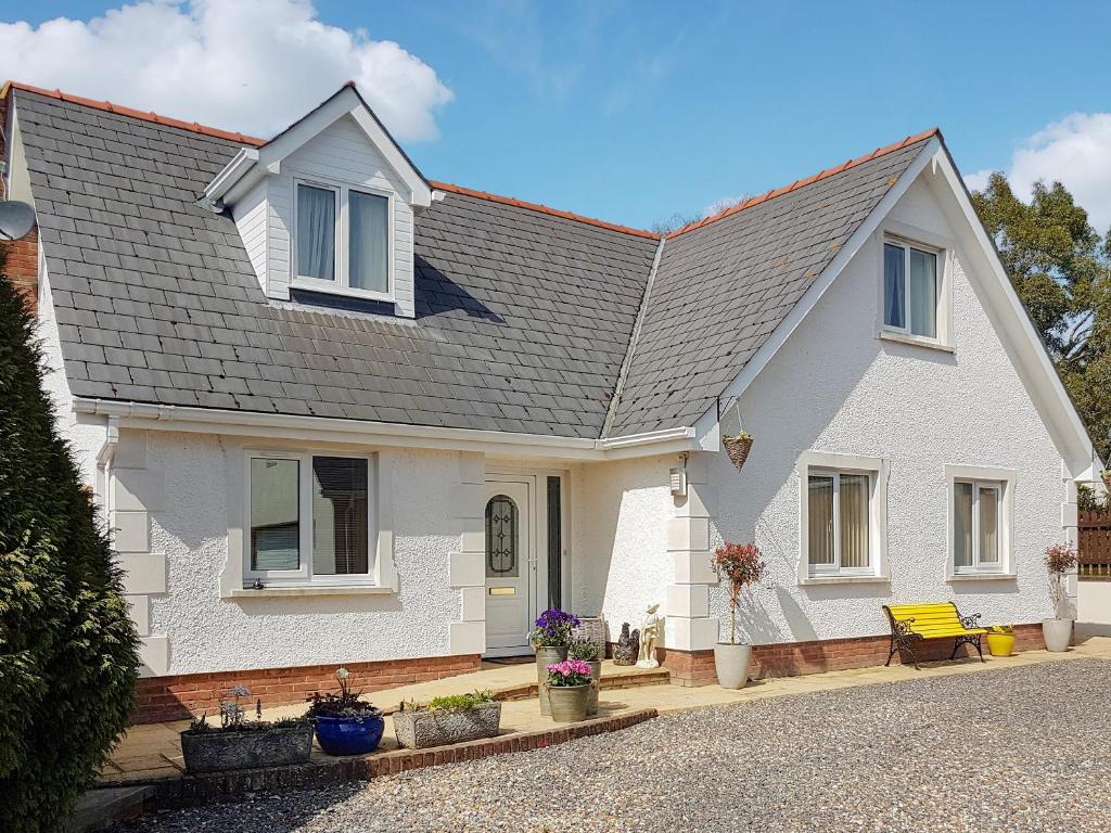 a white house with a gray roof at Rhosyn Gwyn in Llechryd