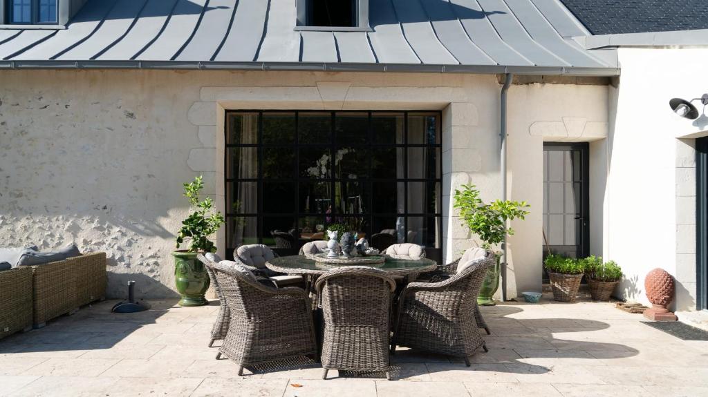 a patio with a table and wicker chairs at Domaine Du Turbais in Luynes