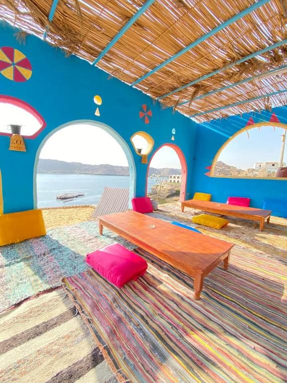 a living room with a table and two benches at Heissa Nubian Hostel in Aswân Reservoir Colony
