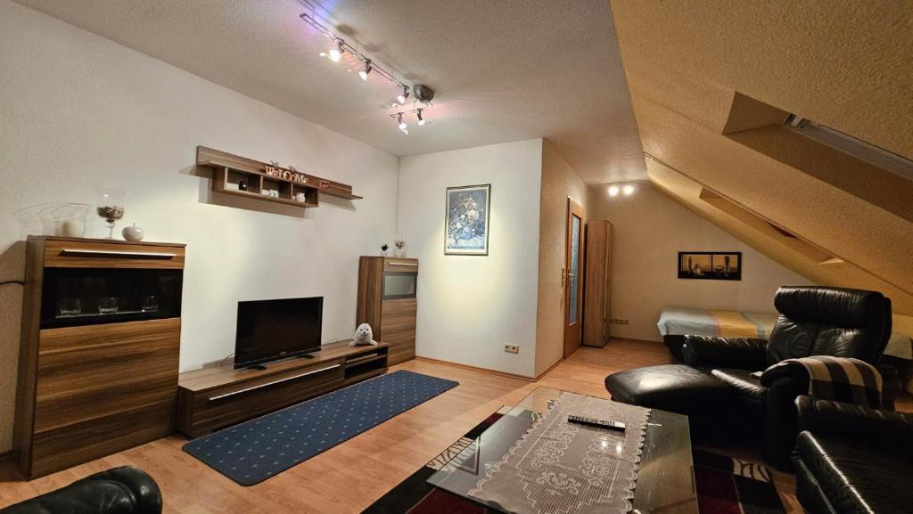 a living room with a couch and a tv at Fewo Wilhelmshaven Langewerth in Roffhausen