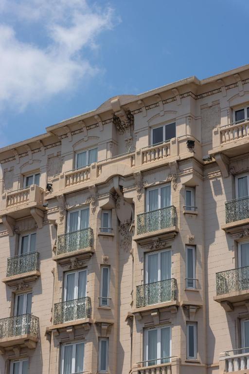 a building with balconies on the side of it at Hotel Renoir in Cannes