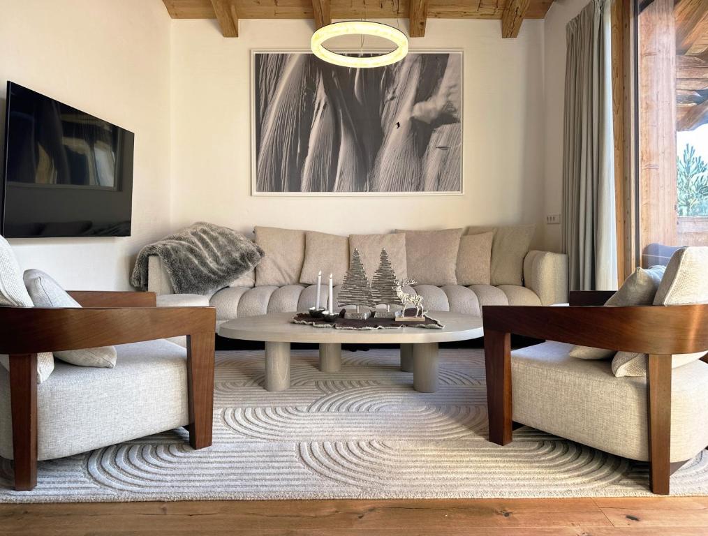 salon z kanapą i stołem w obiekcie AlpenPura - Chalet mit Sauna und Panoramablick w mieście Neukirchen am Großvenediger