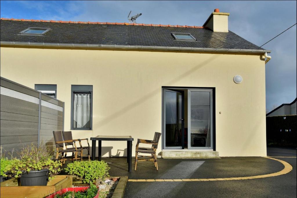 a small white house with a table and chairs at Gite 2 Le Logis des grenouilles in Lamballe Armor