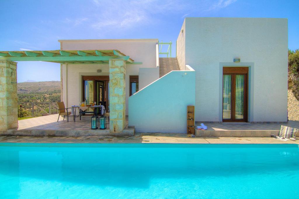 een villa met een zwembad en een huis bij Villa Ikaros in Agia Triada