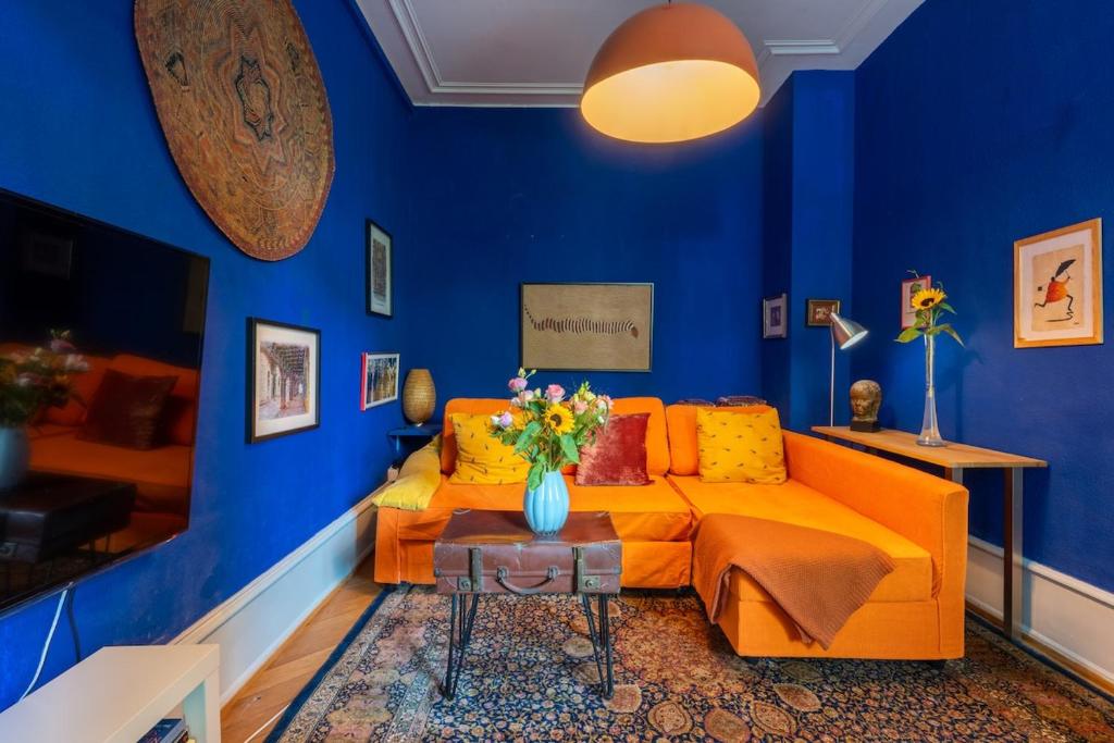 a living room with an orange couch and blue walls at Historic Gem - Lift - Balcony in Basel