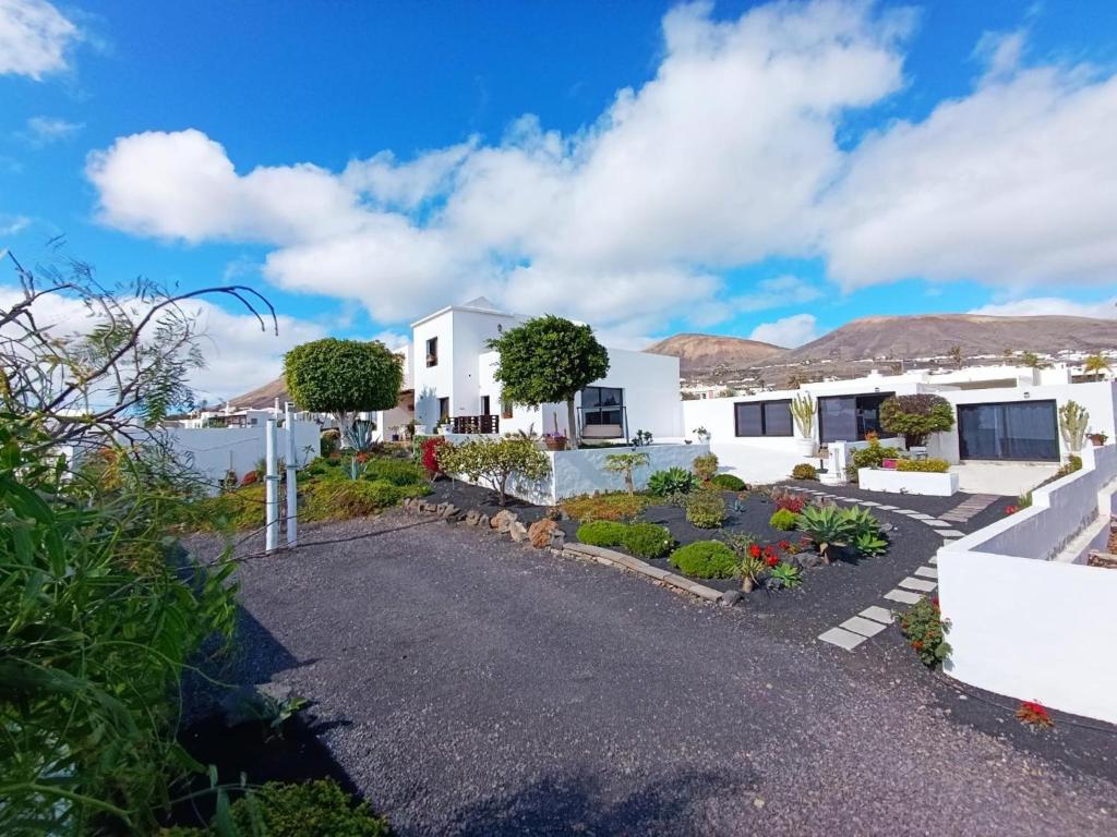 una casa blanca con un jardín delante en Villa Lilli, en La Asomada
