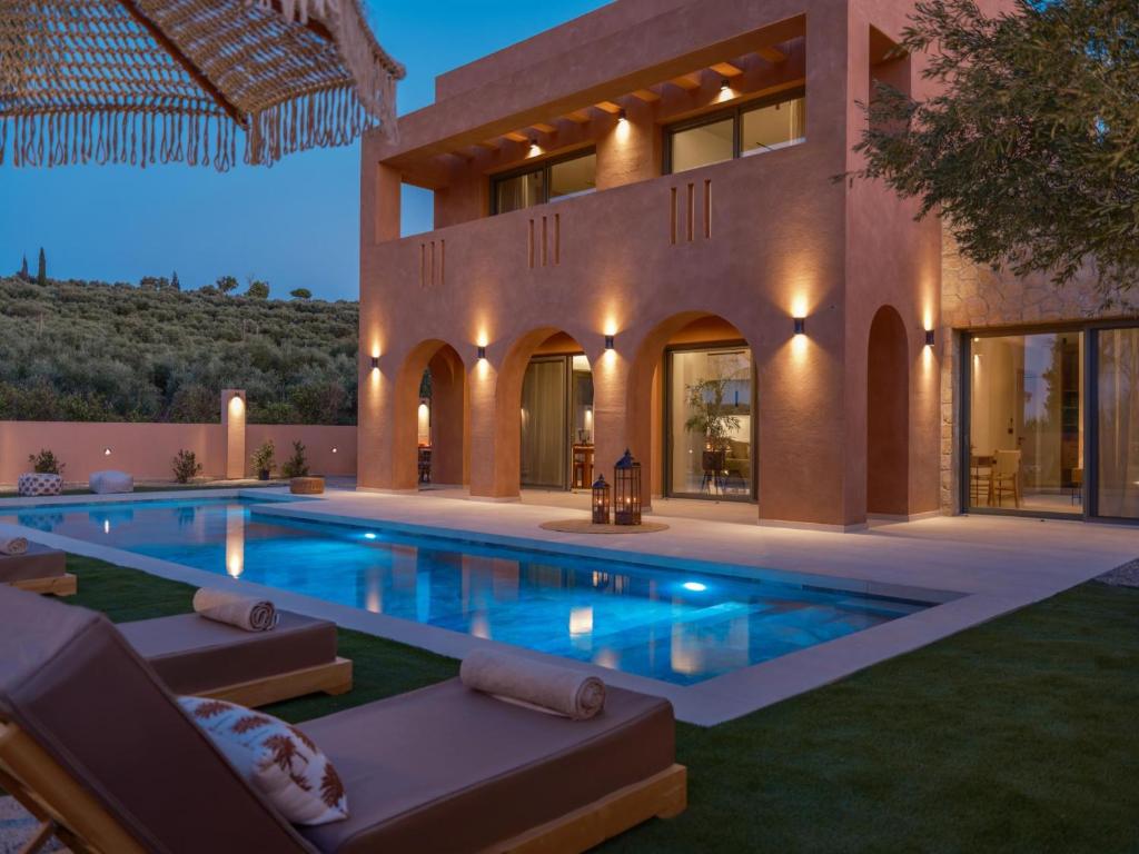 a large house with a swimming pool in front of it at Sol in Amoudi