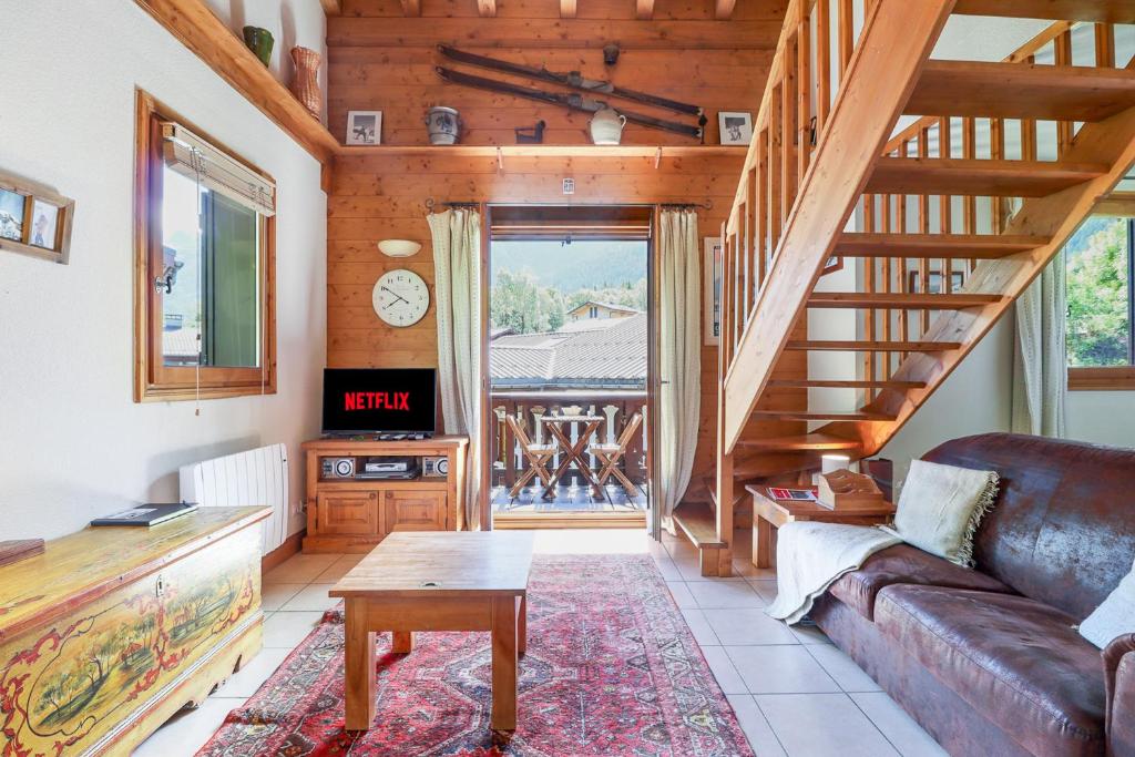 a living room with a couch and a staircase at Amethyste - 2 Bedrooms & Free Parking - By Cozee Rentals in Les Houches