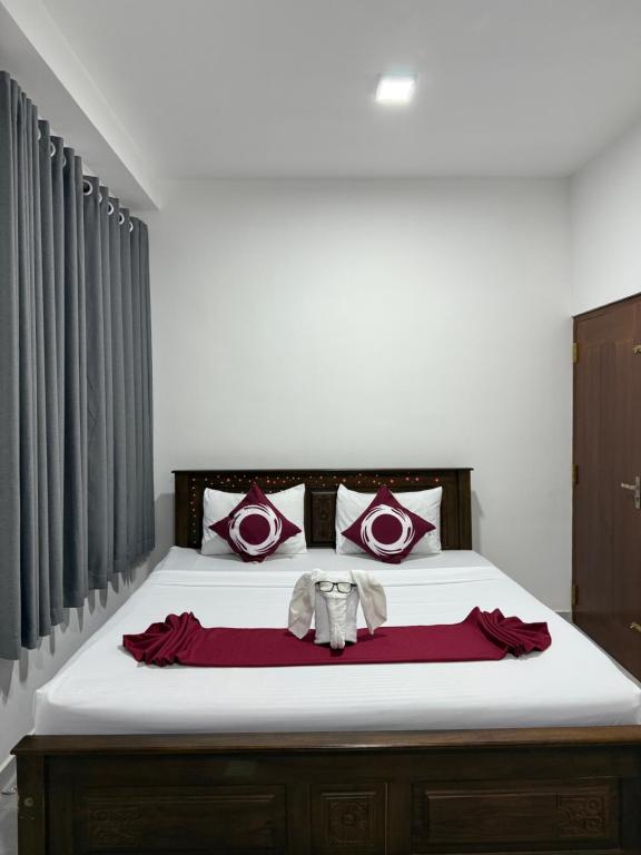 a bedroom with a large bed with red and white pillows at Dewliya Rest in Galle