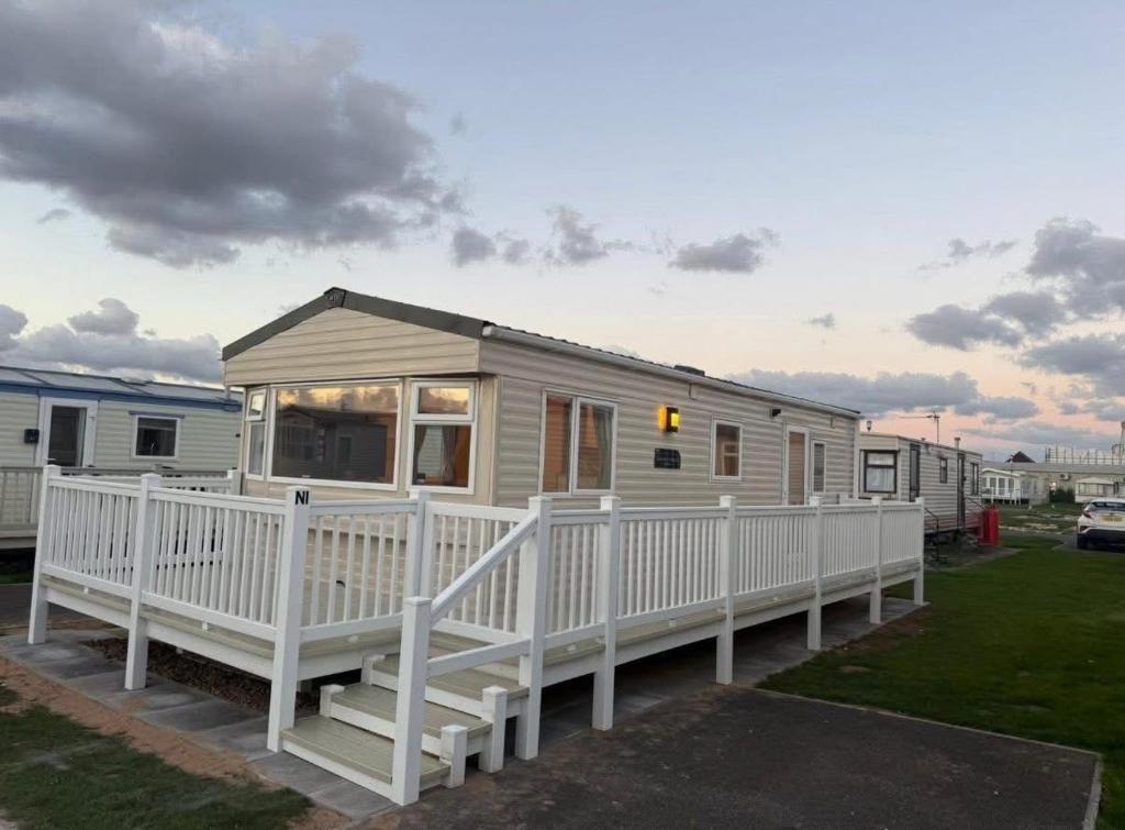 Mobilheim mit einem weißen Zaun im Hof in der Unterkunft Summer Breeze Deluxe in Skegness