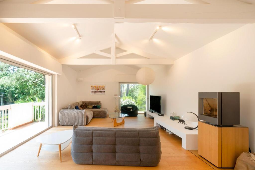 un soggiorno con un divano e una TV di Villa Piscine Entre Lac et Océan a Soorts-Hossegor