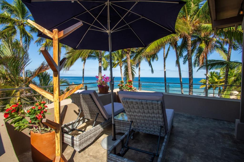 a patio with a table and chairs and an umbrella at Casas Palmar and Tocayo in Sayulita