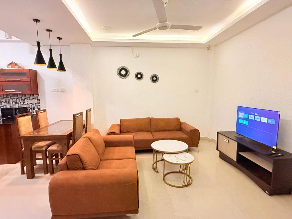 マウントラビニアにあるPearl Breeze Luxury Apartmentsのソファ、テレビ、テーブルのあるリビングルーム