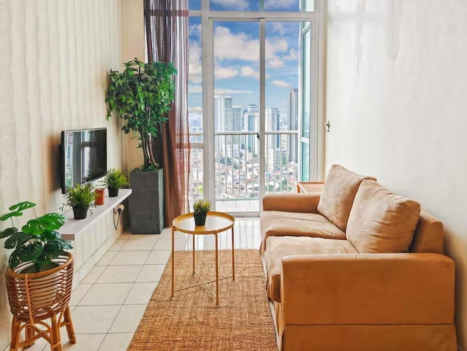 a living room with a couch and a large window at Newly Large 2BR Ambassador2 Apt with Pool Gym WiFi in Jakarta