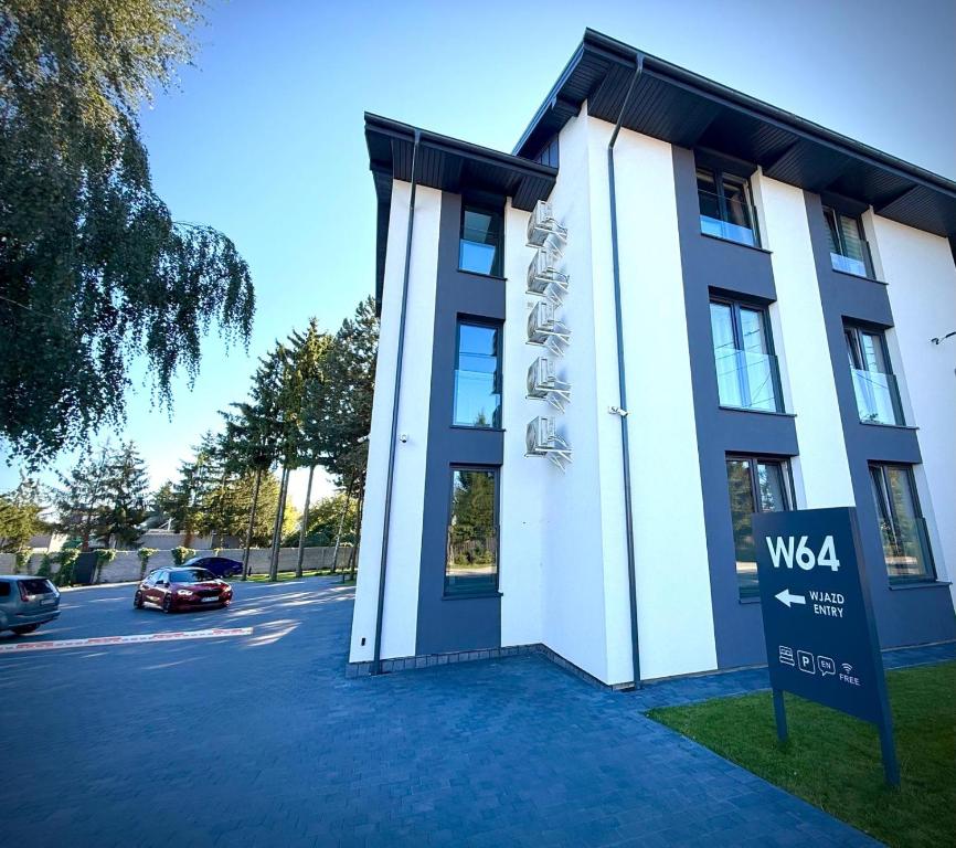 a building with a sign in front of it at W64 Apartamenty in Płock