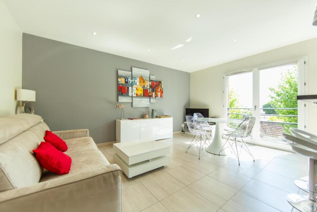 a living room with a couch and a table at Appartement Villa De L'Arche en plein centre-ville in Andernos-les-Bains