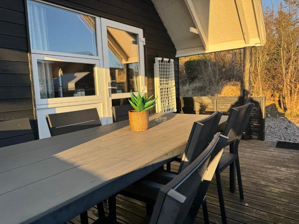 a wooden table and chairs on a deck at Vedersø Strand Camping in Ulfborg