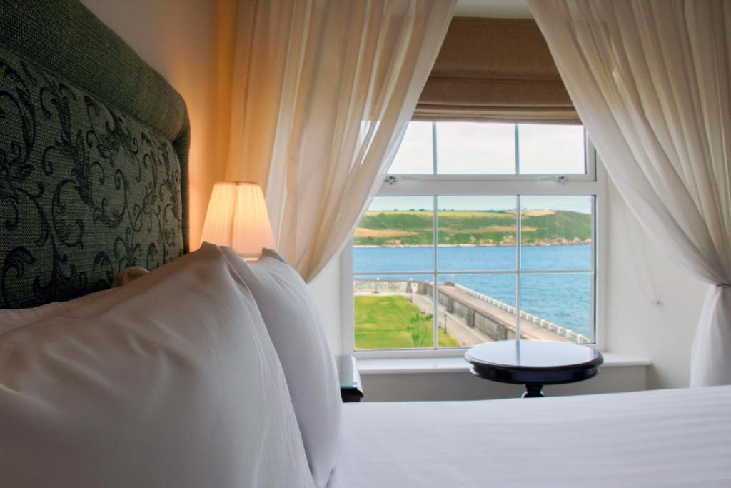 a bedroom with a bed with a view of the ocean at Walter Raleigh Hotel in Youghal