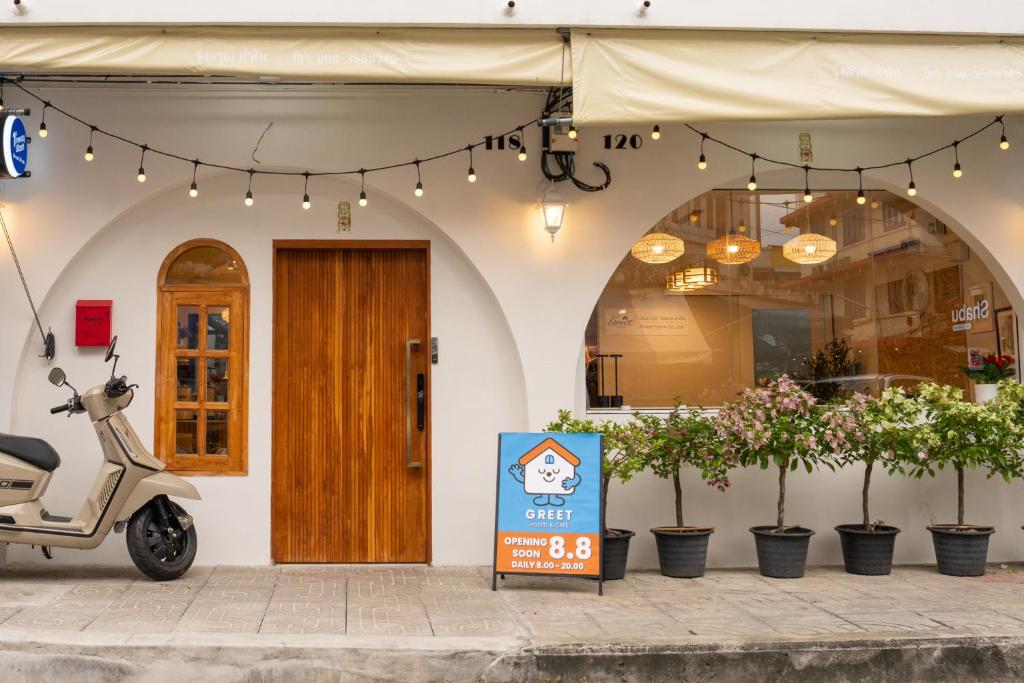 uno scooter parcheggiato di fronte a un edificio con un cartello di Greet Hostel & Cafe Samyan a Bangkok