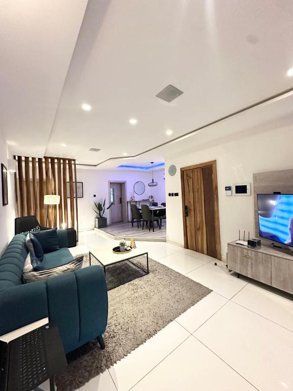 BamgboseにあるThe Opalの青いソファとテレビのあるリビングルーム