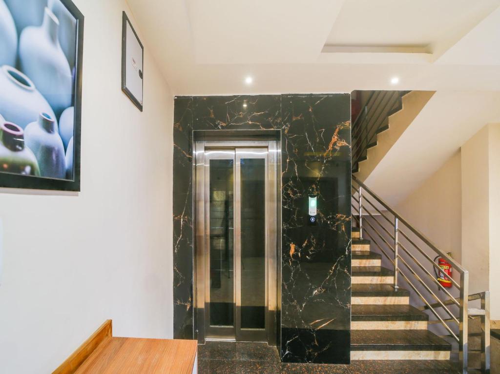 a hallway with a staircase with a black marble wall at Hotel O Zamzam Residency in Bhopal