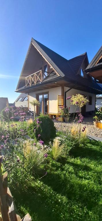 a house with a garden in front of it at Hrube DOMKI Zakopane in Zakopane