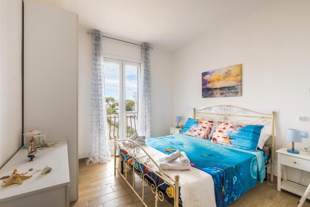 a bedroom with a blue bed and a balcony at Maréa Luxury Private Villa in Torre Squillace