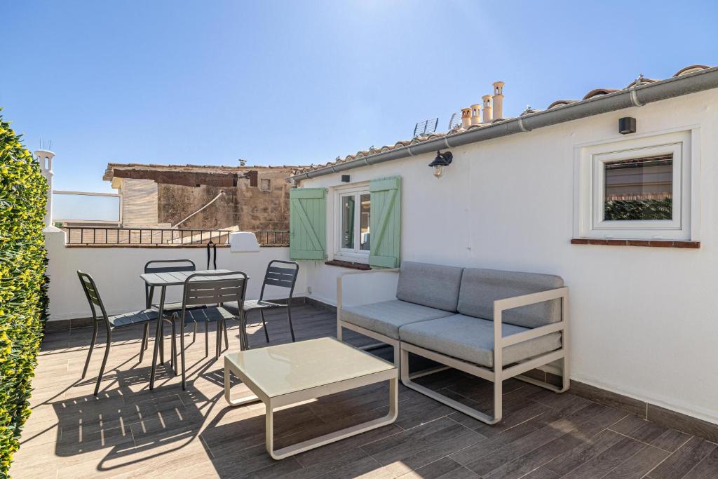 eine Terrasse mit Stühlen, einer Couch und einem Tisch in der Unterkunft Cannes City Suites - 4 appartements neufs au coeur de Cannes in Cannes