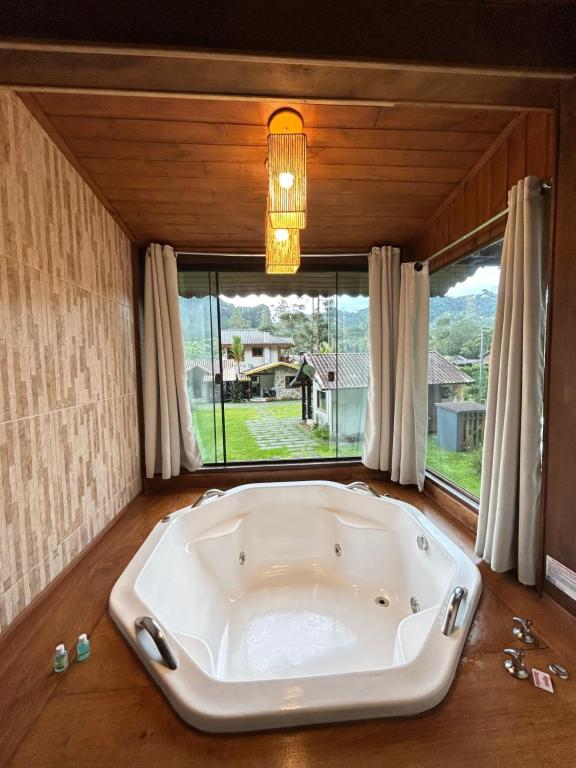 a large bath tub in a room with a window at Recanto Meu Pedacinho de Chão in Visconde De Maua