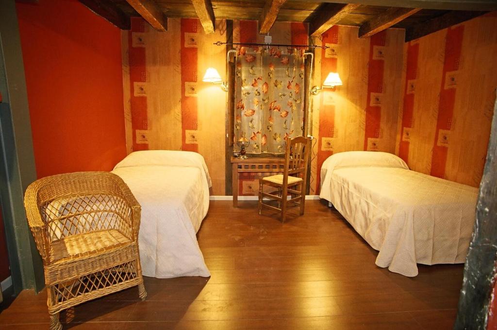 a room with two beds and a chair in it at Reoyo 2 in Mambrilla de Castrejón