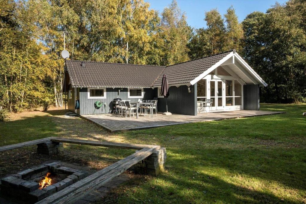 a cottage with a fire pit in the yard at M397-Vaeggerlose-Stolt-Henriksvej-111 in Marielyst