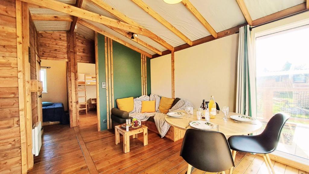 Malleville-les-GrèsにあるDomaine Le Jardin de Séraphineの部屋の中にテーブルと椅子があるダイニングルーム