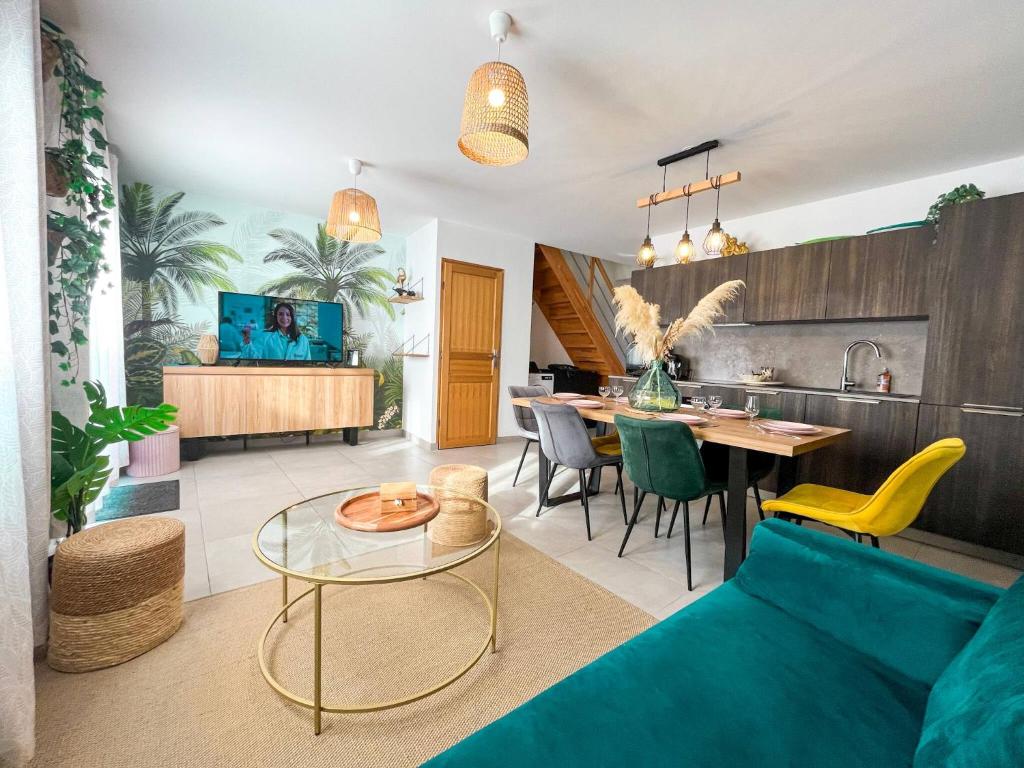 ein Wohnzimmer mit einem blauen Sofa und einem Tisch in der Unterkunft Maison 6 personnes - Etaples in Étaples