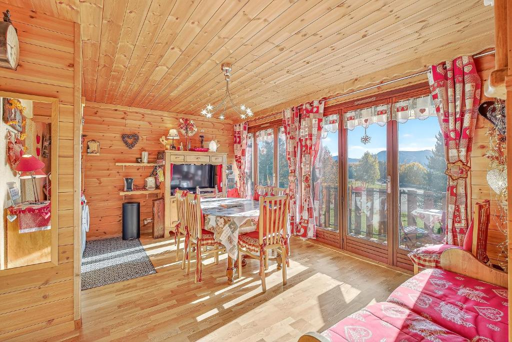 a dining room with a table and some windows at Cosy Et Lumineux À Montclar Alpes in Montclar