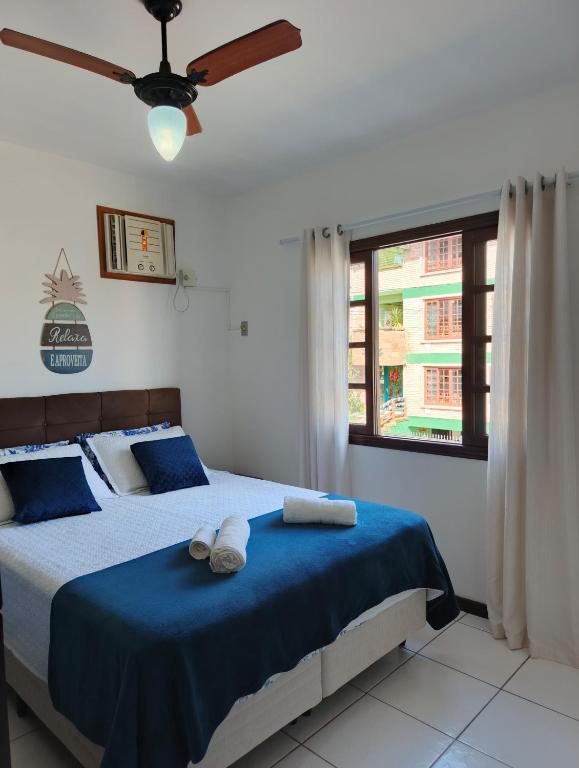 a bedroom with two beds and a ceiling fan at Residencial DO MAR in Bombinhas