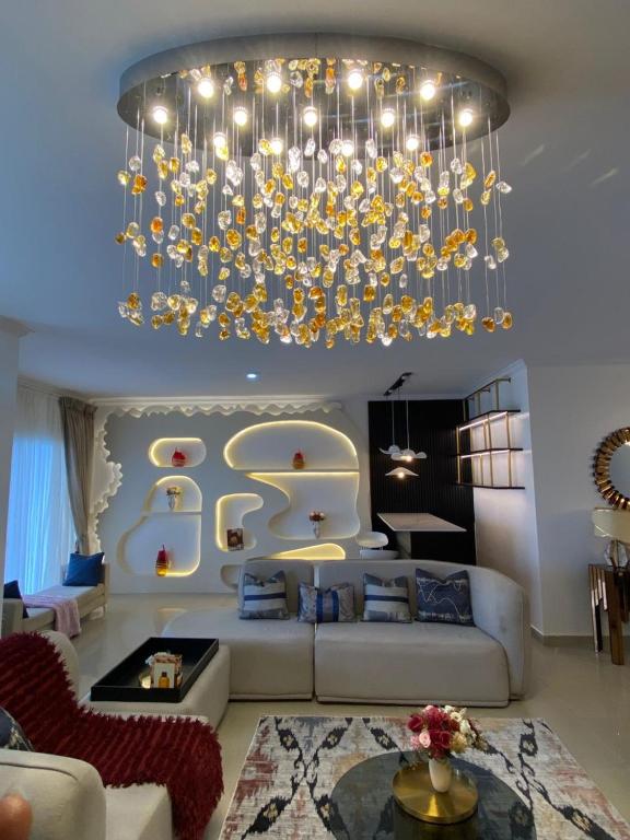 una gran sala de estar con una gran lámpara de araña. en Maison Apartment, en Lagos