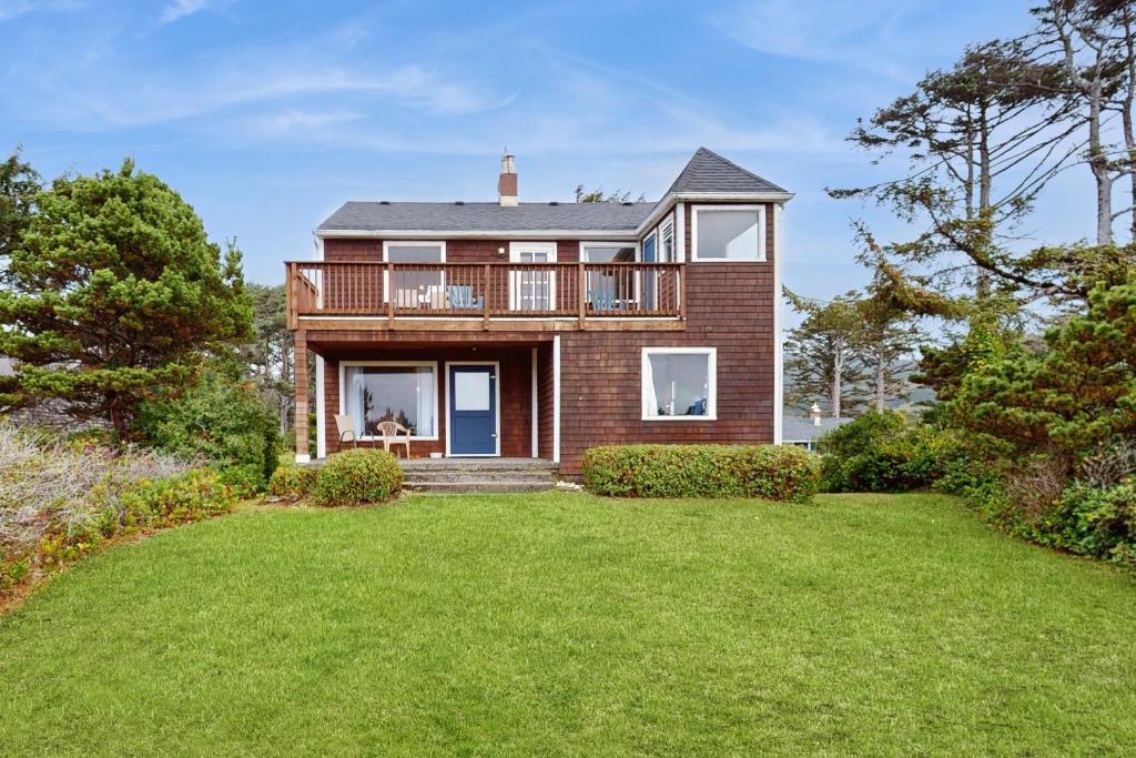 a large house with a balcony and a yard at McKinnon's Beach House in Rockaway Beach