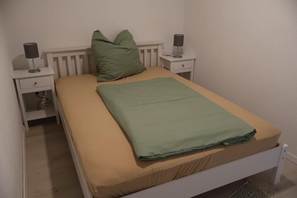 a small bed with two night stands and a green pillow at Ferienwohnung Spielmann in Sauldorf