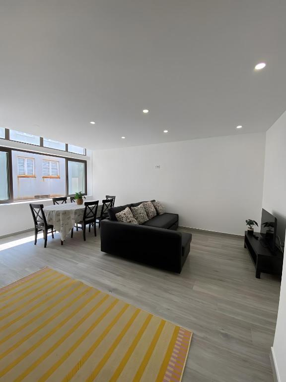 a living room with a couch and a table at T4 Furadouro with sea view in Furadouro