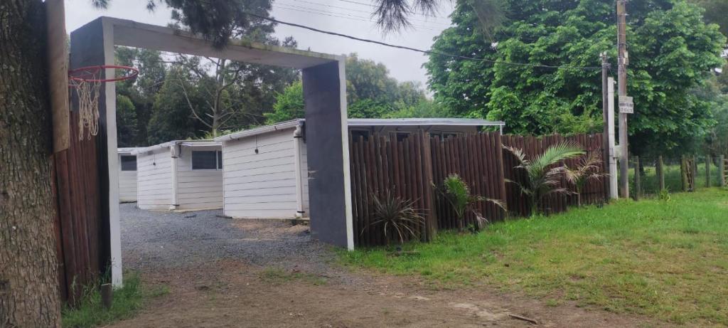 an open gate in a fence with a basketball hoop at cabañas en cuchilla alta in Cuchilla Alta
