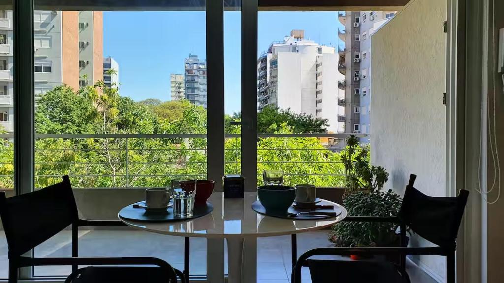 a table and chairs in a room with a large window at Monoambiente encantador en Nuñez in Buenos Aires