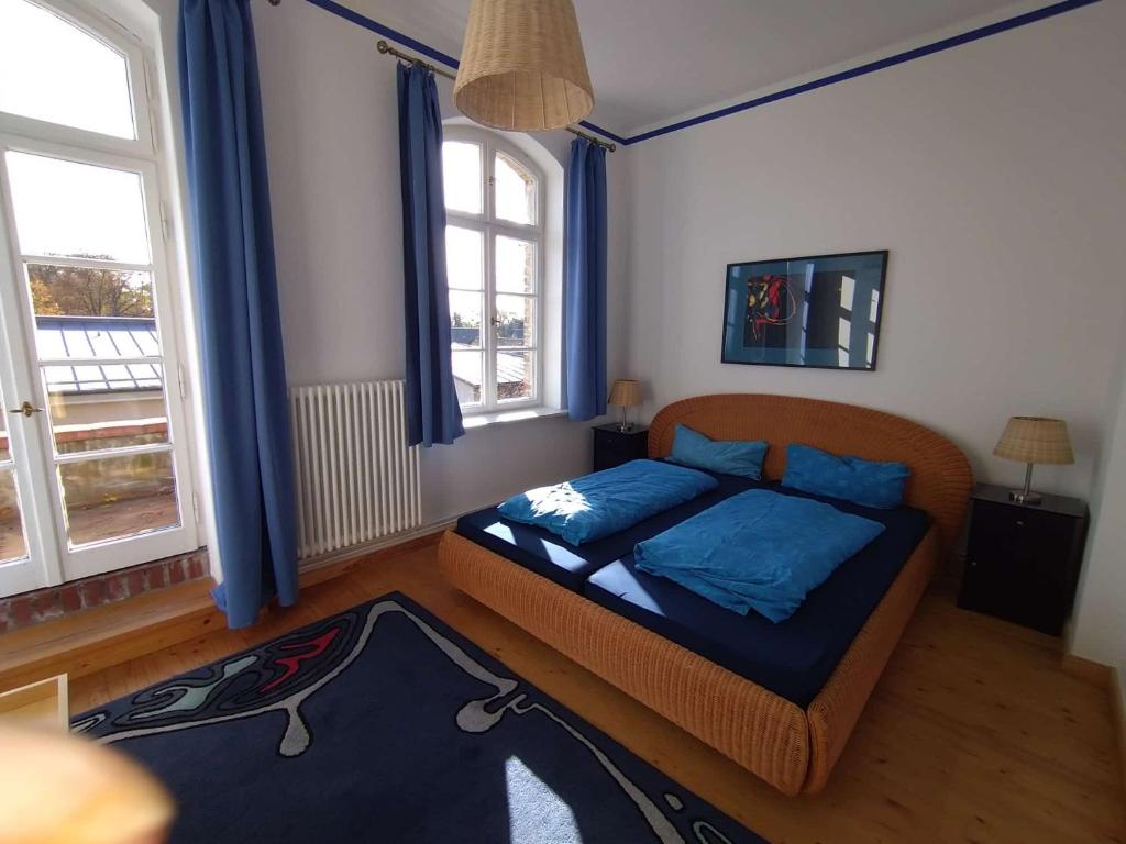 a bedroom with a bed with blue pillows at Zwei "Giebelwohnungen" im Kunstgut Krahne in Krahne
