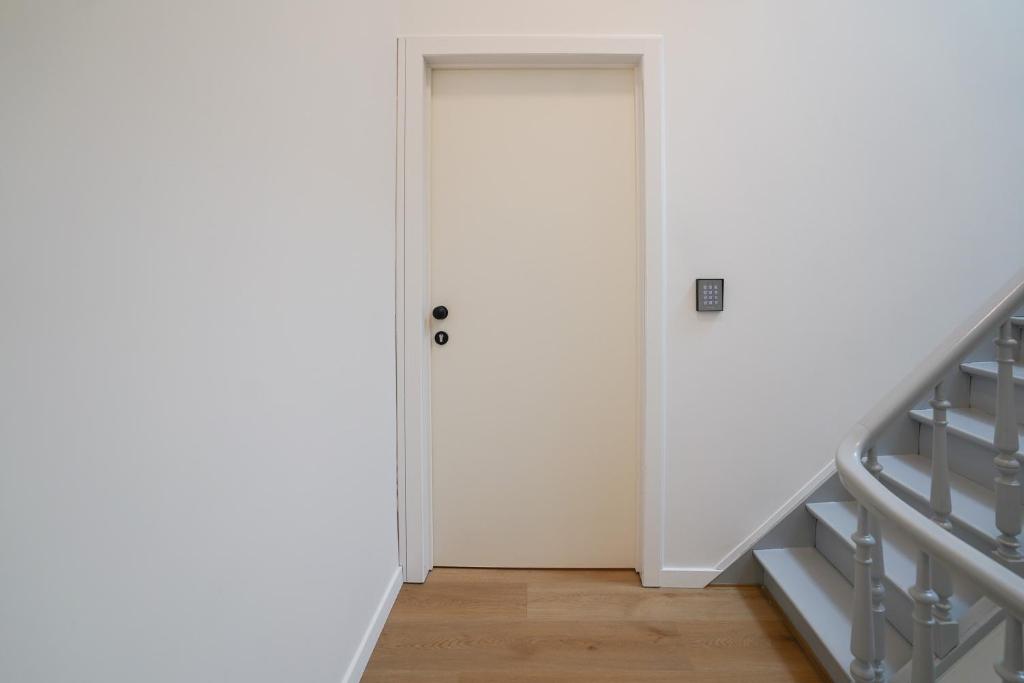 une porte blanche dans une pièce avec un escalier dans l'établissement Appartment Veeweyde 5, à Bruxelles