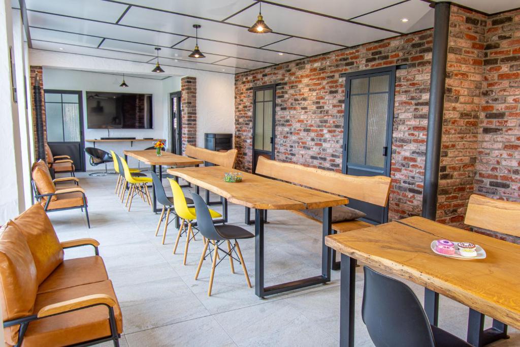 a restaurant with wooden tables and chairs and brick walls at Traumraum Wittendorf in Loßburg