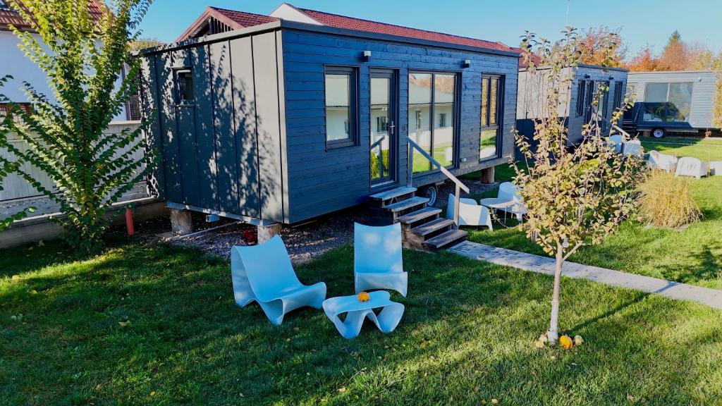 トゥルグ・セクイエスクにあるPixel - Tiny Campusの庭に青い椅子が置かれた小さな家